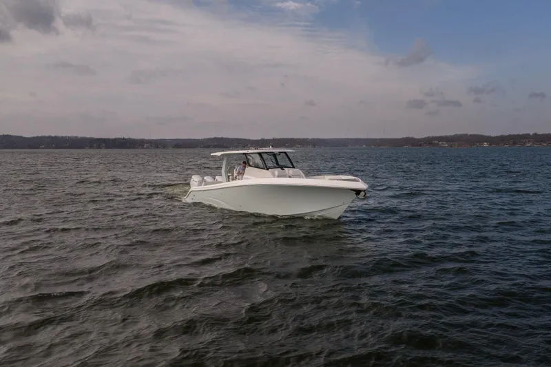 Slide: The Image of 2026 Fountain 43 SCX boat cruising on a calm lake under a cloudy sky. - 6