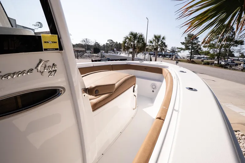 Slide: The Image of 2021 Sea Hunt Gamefish 27 Coffin Box boat with tan seating, docked near palm trees. - 10