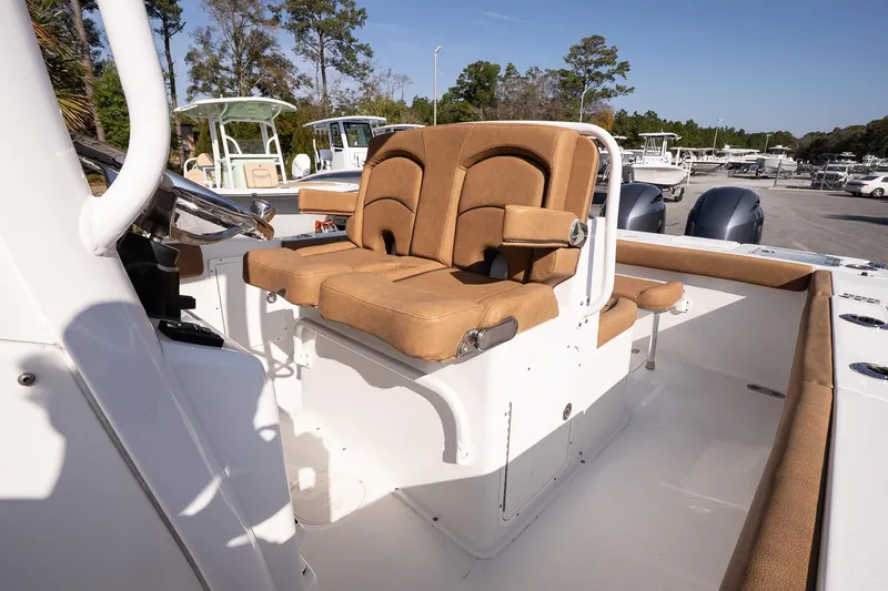 Slide: The Image of 2021 Sea Hunt Gamefish 27 Coffin Box boat interior with tan seating and steering wheel. - 12