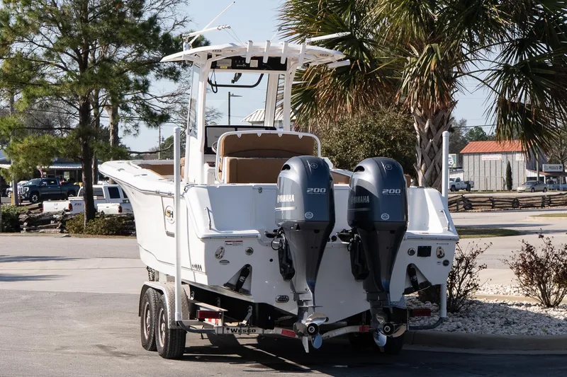 Slide: The Image of 2021 Sea Hunt Gamefish 27 Coffin Box boat with dual Yamaha engines on a trailer. - 4