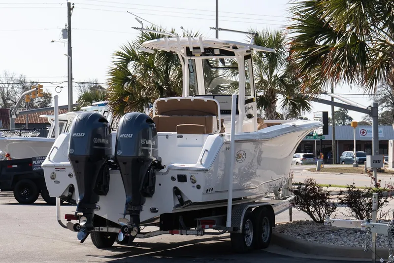 Slide: The Image of 2021 Sea Hunt Gamefish 27 Coffin Box boat with dual Yamaha engines on a trailer. - 6