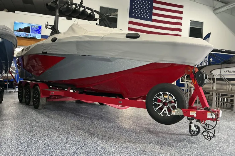Slide: The Image of 2022 Axis T250 boat on red trailer in showroom with American flag. - 23