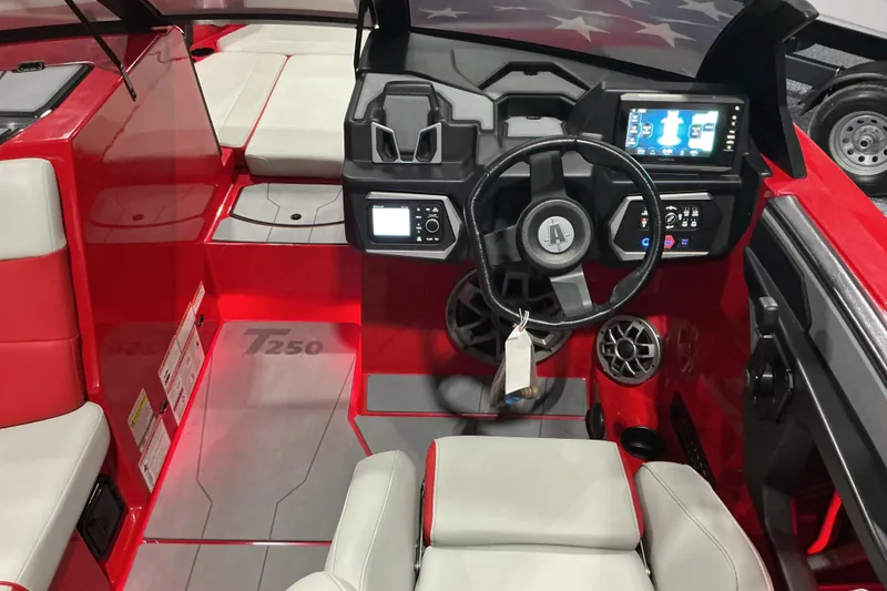 Slide: The Image of 2022 Axis T250 boat interior with red and gray seating, modern dashboard, and steering wheel. - 8