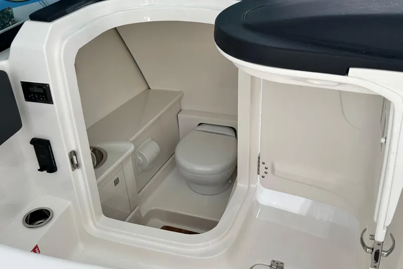 Slide: The Image of 2026 Robalo R277 Dual Console boat interior with compact marine toilet. - 12