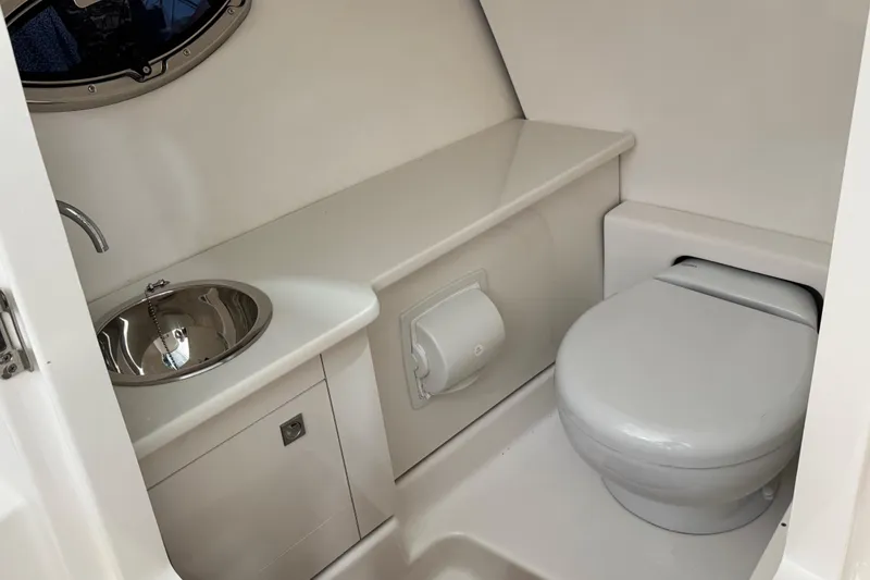 Slide: The Image of 2026 Robalo R277 Dual Console boat bathroom with sink and toilet. - 13
