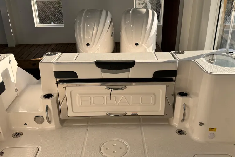 Slide: The Image of 2026 Robalo R277 Dual Console boat interior with dual engines and storage compartment. - 14