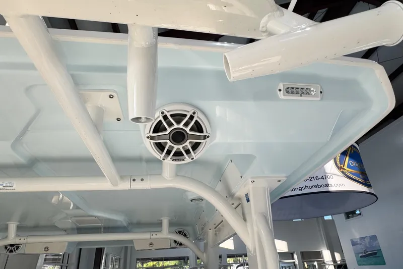 Slide: The Image of 2026 Robalo R277 Dual Console boat interior with speaker and rod holders. - 17