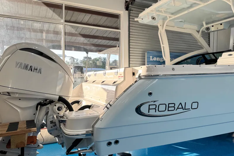 Slide: The Image of 2026 Robalo R277 Dual Console boat with Yamaha outboard engine in showroom. - 6