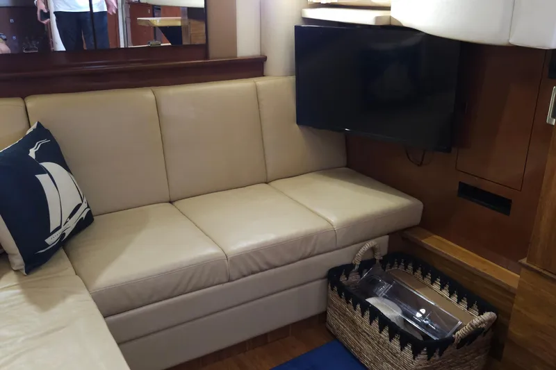 Slide: The Image of Interior of 2008 Sea Ray 40 Sundancer with beige seating, TV, and nautical decor. - 28