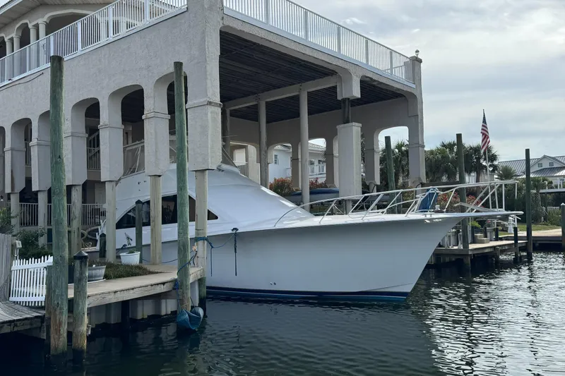 The Image of 2002 Ocean Yachts 56 Super Sport docked by a waterfront home. - 0