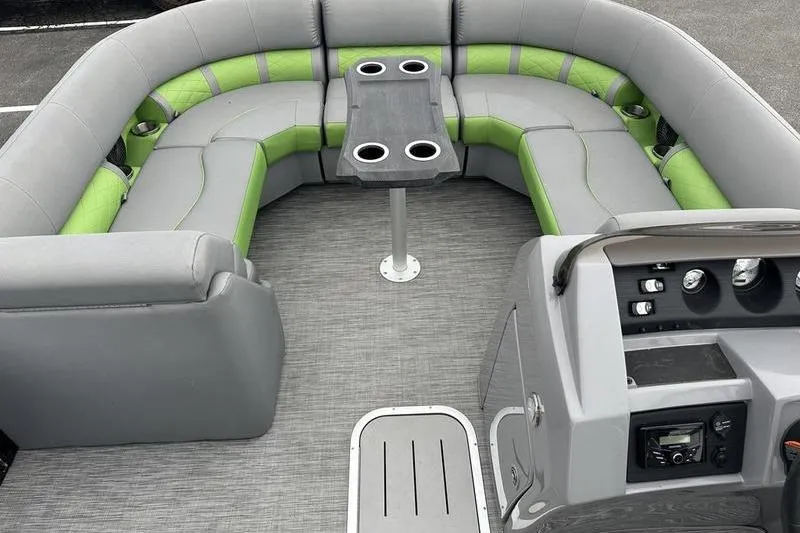 Slide: The Image of 2021 Bennington 22 boat interior with gray and green seating, central table, and control panel. - 13