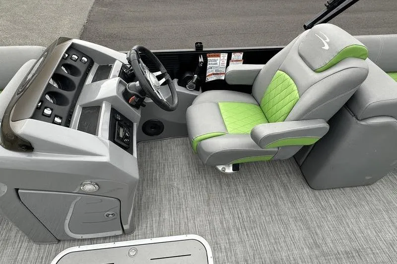 Slide: The Image of 2021 Bennington 22 boat interior with green and gray captain's chair and control panel. - 18
