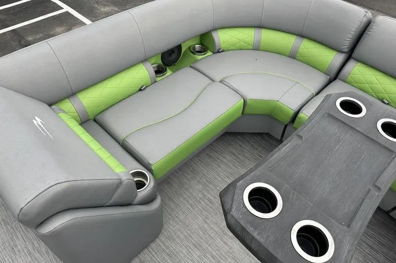 Slide: The Image of 2021 Bennington 22 boat interior with gray and green seating, cup holders, and table. - 19