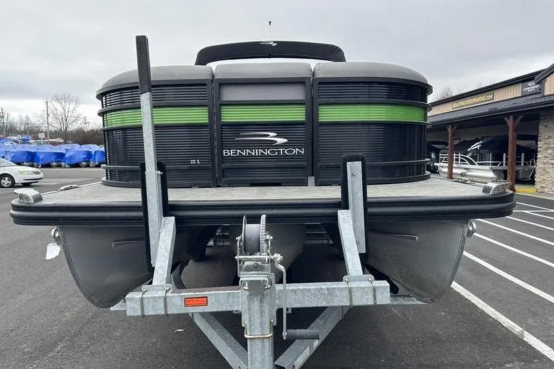 Slide: The Image of 2021 Bennington 22 pontoon boat on trailer, front view in parking lot. - 2