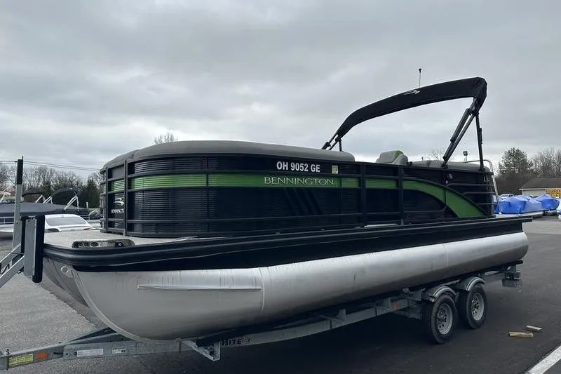Slide: The Image of 2021 Bennington 22 pontoon boat on trailer, overcast sky background. - 22