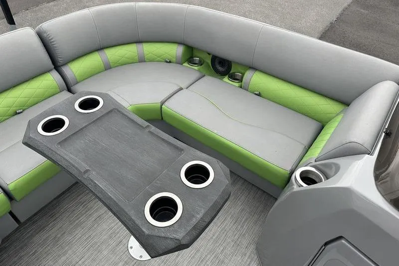 Slide: The Image of 2021 Bennington 22 boat interior with gray and green seating, cup holders, and table. - 9