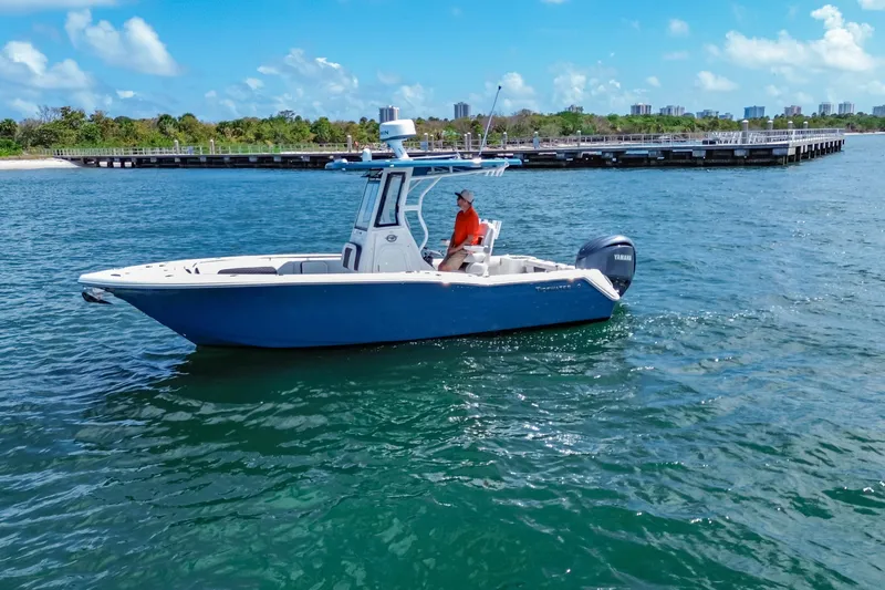 Slide: The Image of 2026 Tidewater 232 LXF boat cruising on clear blue water near a dock. - 10