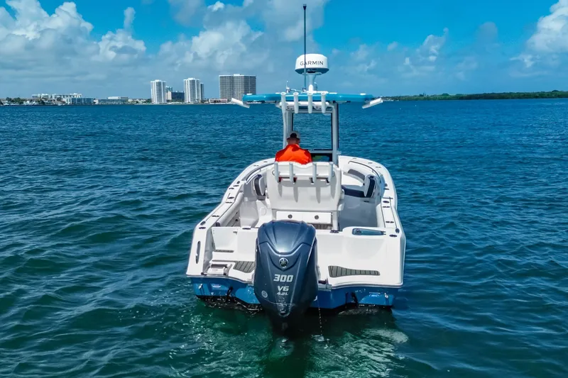 Slide: The Image of 2026 Tidewater 232 LXF boat cruising on blue ocean with city skyline in background. - 12