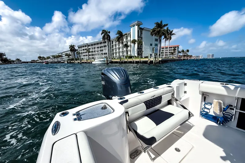 Slide: The Image of 2026 Tidewater 232 LXF boat on water near coastal buildings and palm trees. - 19