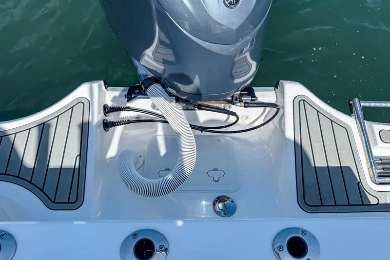 Slide: The Image of 2026 Tidewater 232 LXF boat engine area with deck details and water backdrop. - 22