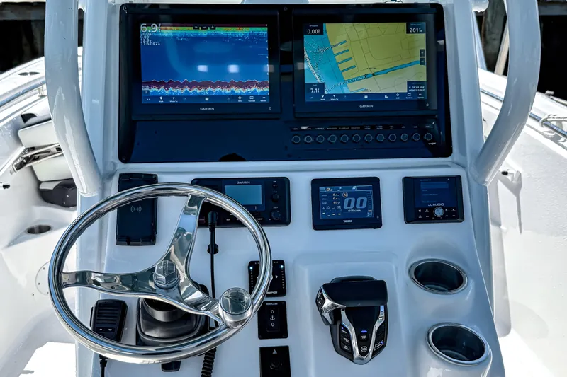 Slide: The Image of 2026 Tidewater 232 LXF boat dashboard with Garmin navigation screens and steering wheel. - 24