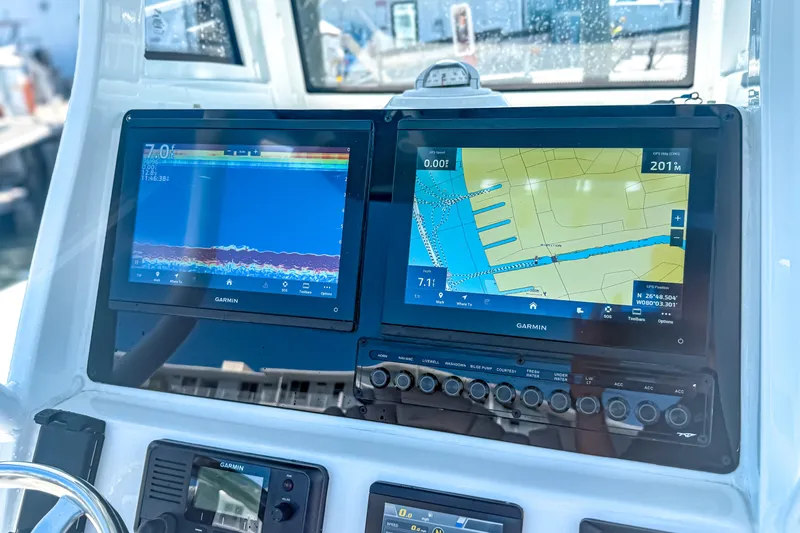 Slide: The Image of 2026 Tidewater 232 LXF boat dashboard with dual Garmin navigation displays. - 25