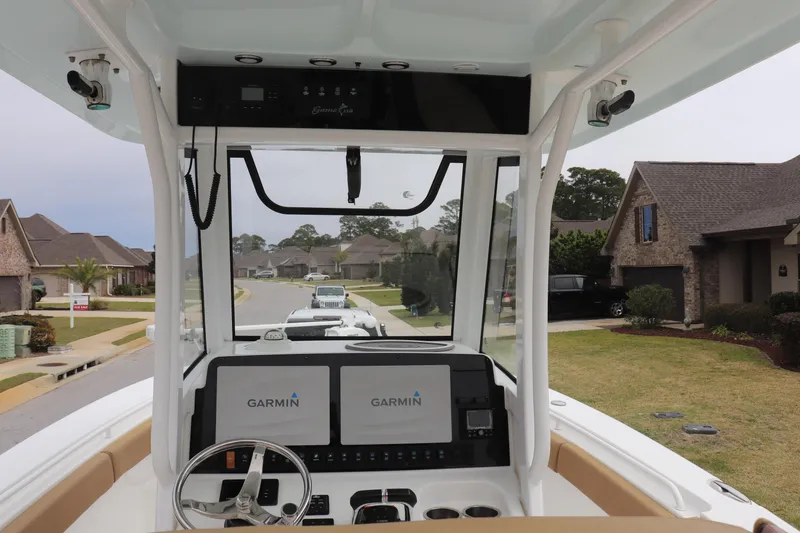 Slide: The Image of 2020 Sea Hunt Gamefish 27 boat with Garmin displays, parked in a suburban neighborhood. - 3