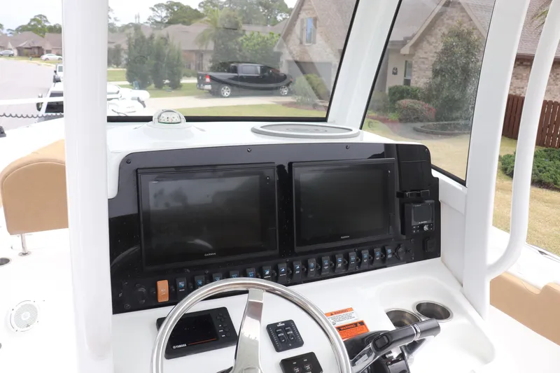 Slide: The Image of 2020 Sea Hunt Gamefish 27 dashboard with dual screens and steering wheel. - 4