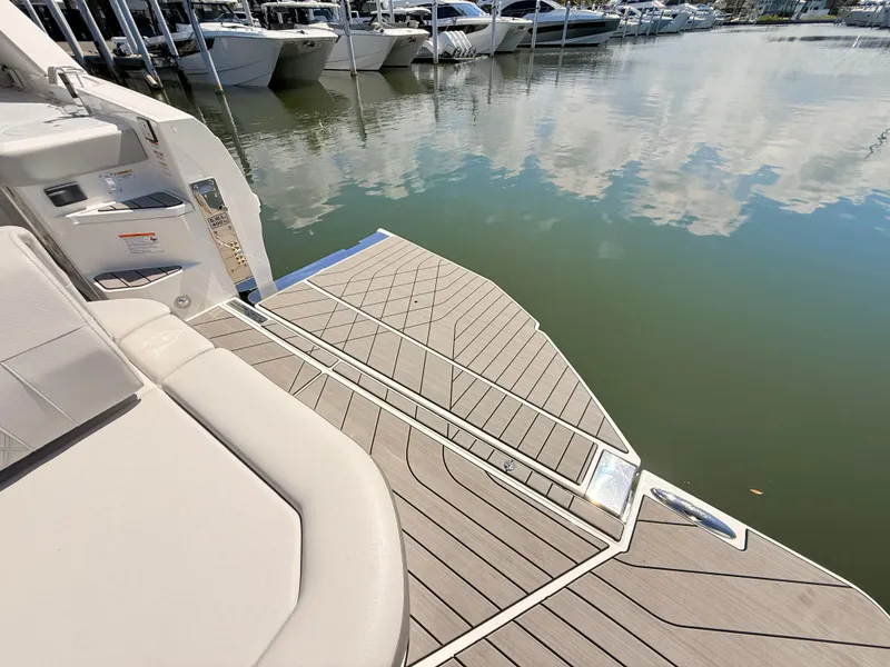 Slide: The Image of 2026 Sea Ray SLX 400 Outboard with sleek swim platform at marina. - 33