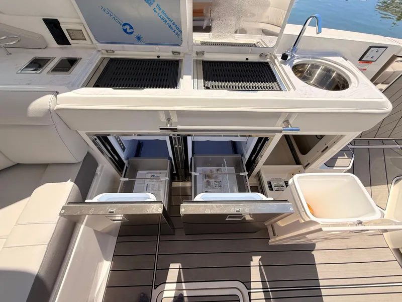 Slide: The Image of 2026 Sea Ray SLX 400 Outboard boat kitchen with sink and storage. - 44