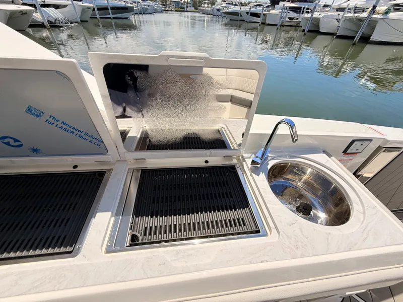 Slide: The Image of Sea Ray SLX 400 Outboard 2026 with grill and sink at marina. - 46
