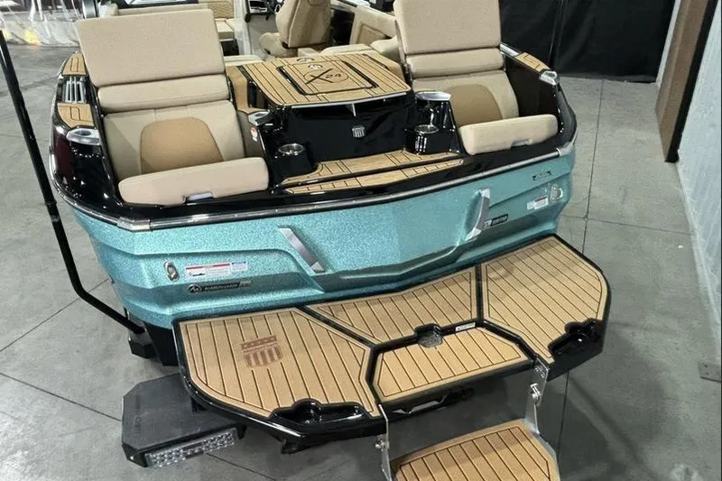 Slide: The Image of 2024 MasterCraft X24 boat with luxurious seating and teak deck, showcased indoors. - 11