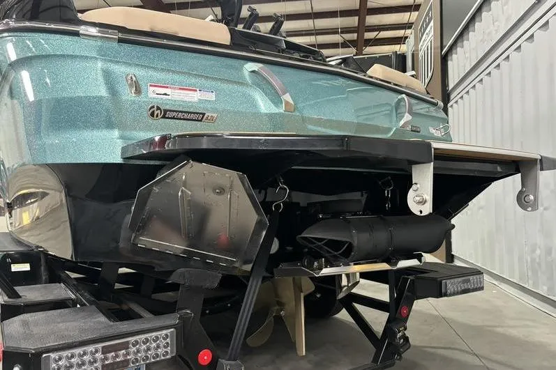 Slide: The Image of 2024 MasterCraft X24 boat rear view in a garage, showcasing its sleek design and features. - 16