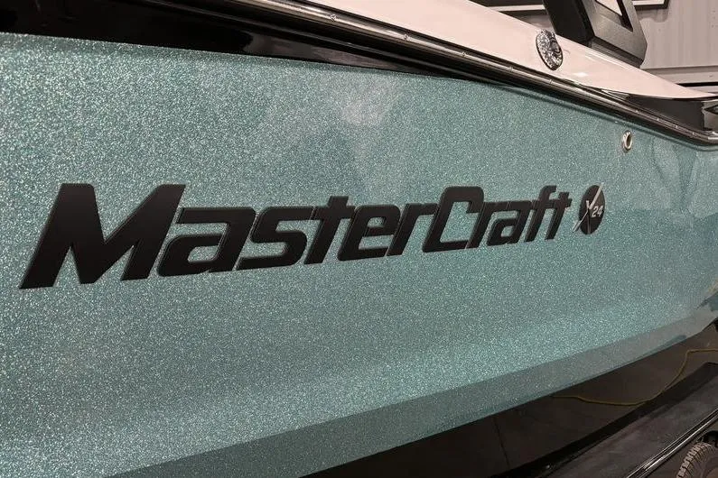 Slide: The Image of 2024 MasterCraft X24 boat with sparkling teal finish and bold logo. - 3