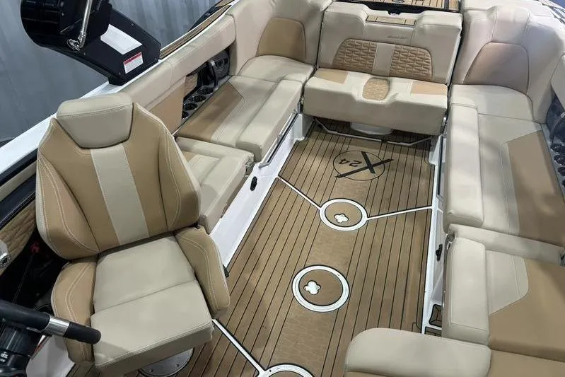 Slide: The Image of 2024 MasterCraft X24 boat interior with luxurious beige seating and teak-style flooring. - 6