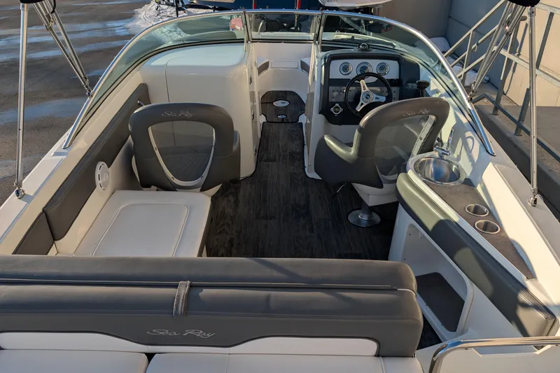 Slide: The Image of 2011 Sea Ray 240 Sundeck interior with seating, steering wheel, and sink. - 10