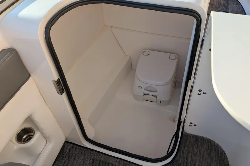 Slide: The Image of 2011 Sea Ray 240 Sundeck boat interior with compact marine toilet. - 12