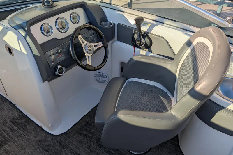 Slide: The Image of 2011 Sea Ray 240 Sundeck cockpit with steering wheel and captain's chair. - 13