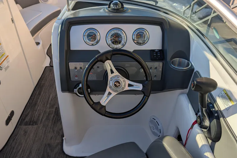 Slide: The Image of 2011 Sea Ray 240 Sundeck dashboard with steering wheel and control panel. - 14