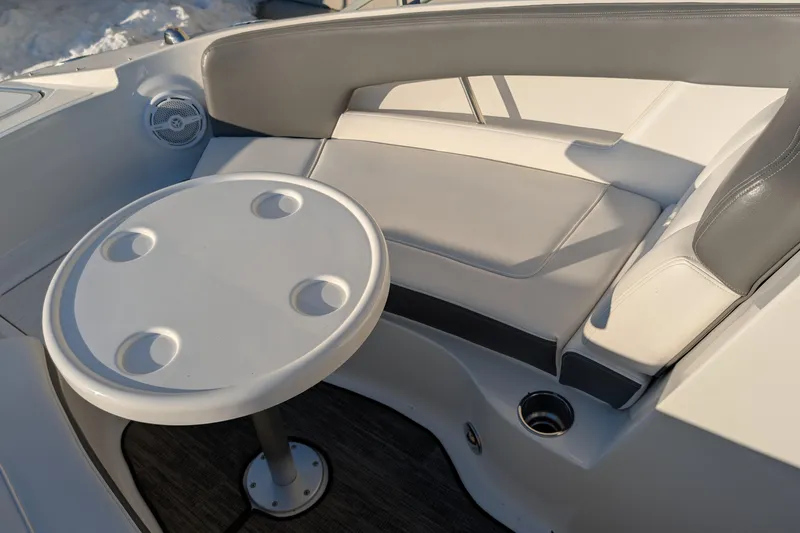 Slide: The Image of 2011 Sea Ray 240 Sundeck interior with round table and cushioned seating. - 18