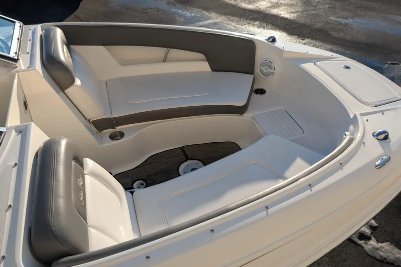 Slide: The Image of 2011 Sea Ray 240 Sundeck boat interior with cushioned seating and cup holders. - 7
