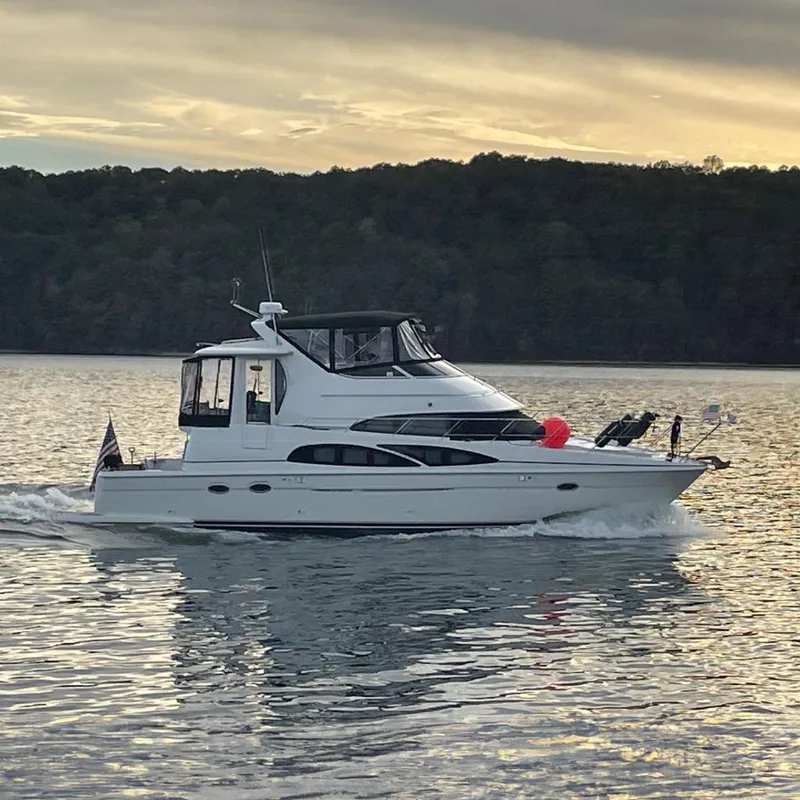 The Image of 2005 Carver 444 Cockpit Motor Yacht cruising on calm water at sunset. - 0