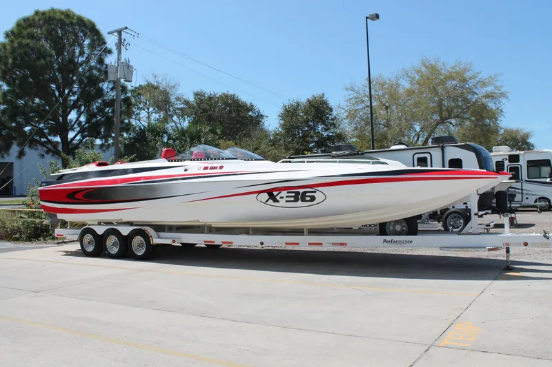 The Image of 2004 Spectre 36 Cat powerboat on trailer, featuring sleek design and vibrant red accents. - 1