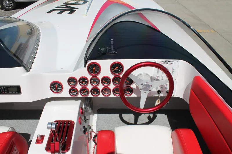 Slide: The Image of 2004 Spectre 36 Cat boat dashboard with red accents and multiple gauges. - 10