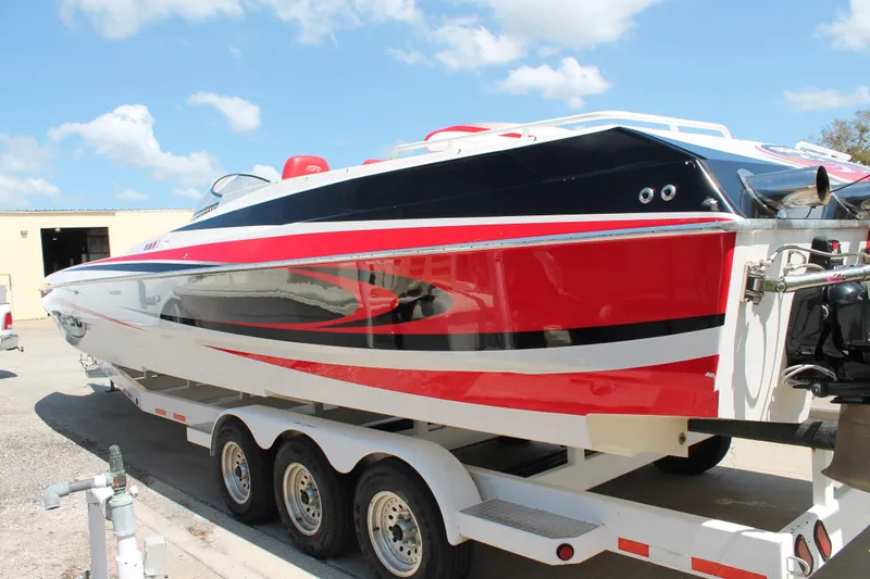 Slide: The Image of 2004 Spectre 36 Cat powerboat with red, black, and white design on a trailer. - 6
