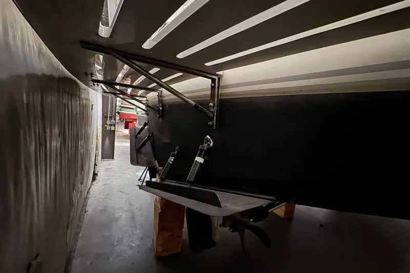 Slide: The Image of 1989 Dyna Craft 45 boat underside in storage, showing propeller and support structures. - 14