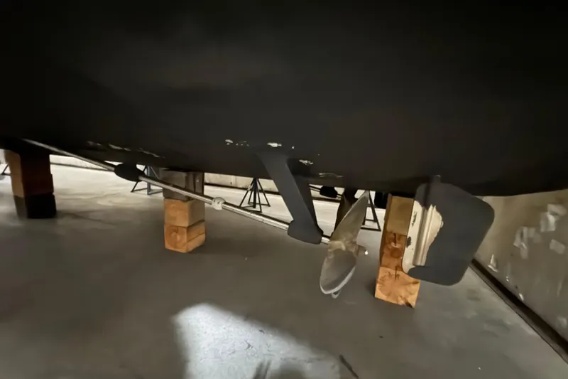 Slide: The Image of Underneath view of a 1989 Dyna Craft 45 boat on wooden blocks. - 15