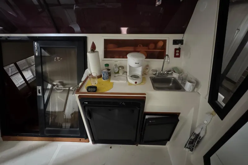 Slide: The Image of Compact kitchen area in a 1989 Dyna Craft 45 boat with sink and appliances. - 22