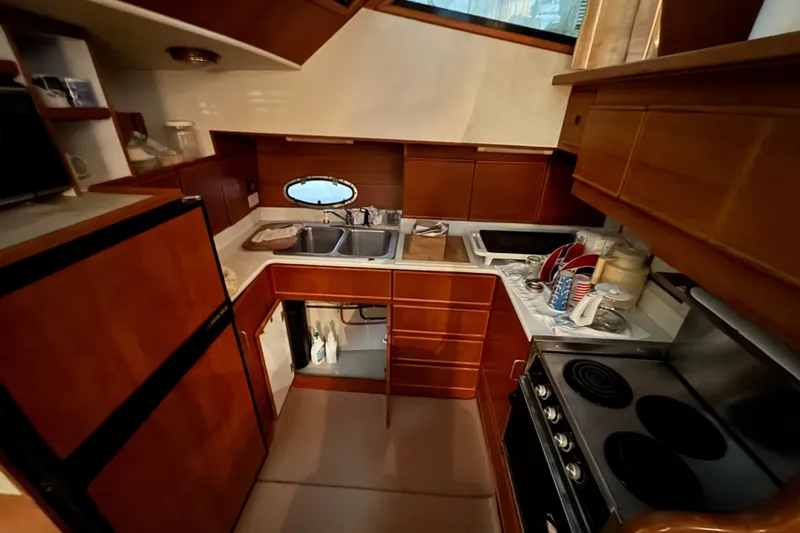 Slide: The Image of 1989 Dyna Craft 45 yacht kitchen with wooden cabinets, stove, and double sink. - 31