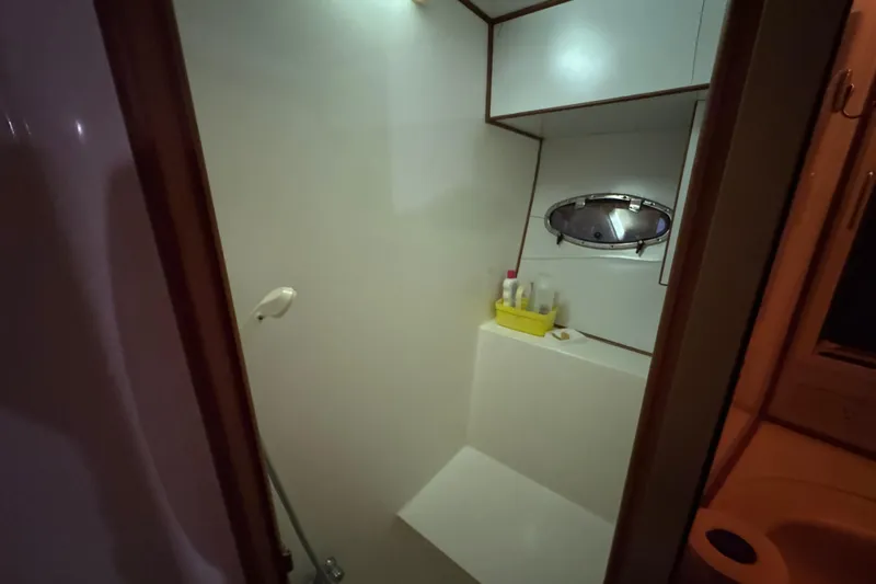 Slide: The Image of Compact bathroom with shower in 1989 Dyna Craft 45 yacht, featuring a porthole window. - 33
